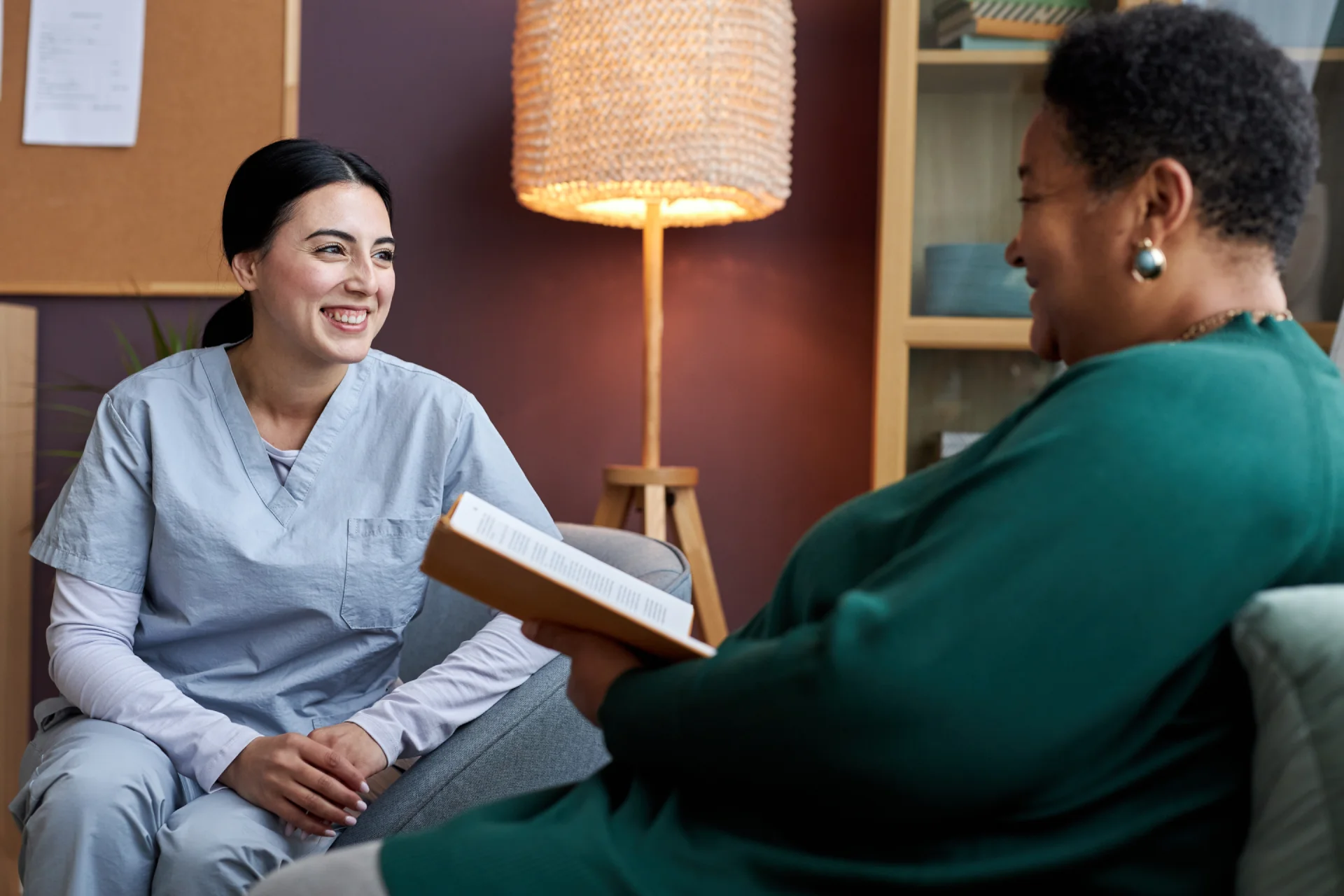Healthcare professional engaging in supportive conversation with a client in a comfortable setting, emphasizing emotional healing and therapeutic support in long-term addiction recovery.