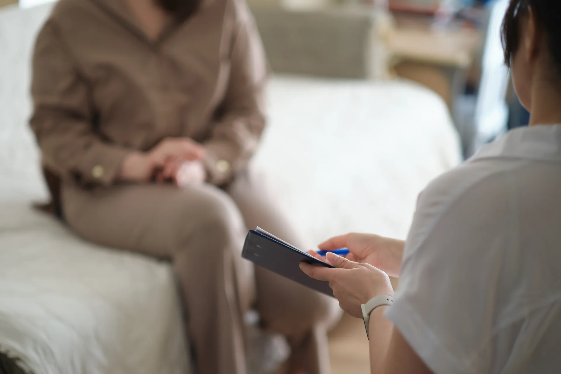 Therapist engaging in one-on-one counseling session with patient, focusing on addiction treatment in a comfortable setting.