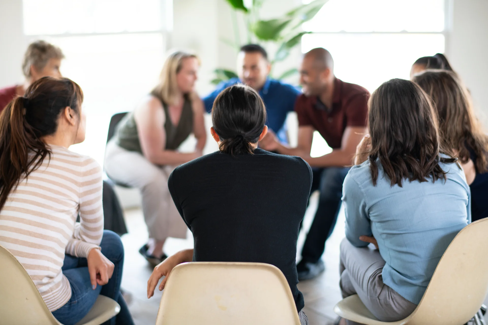Group therapy session for addiction treatment in a bright, supportive environment, emphasizing community and recovery strategies.