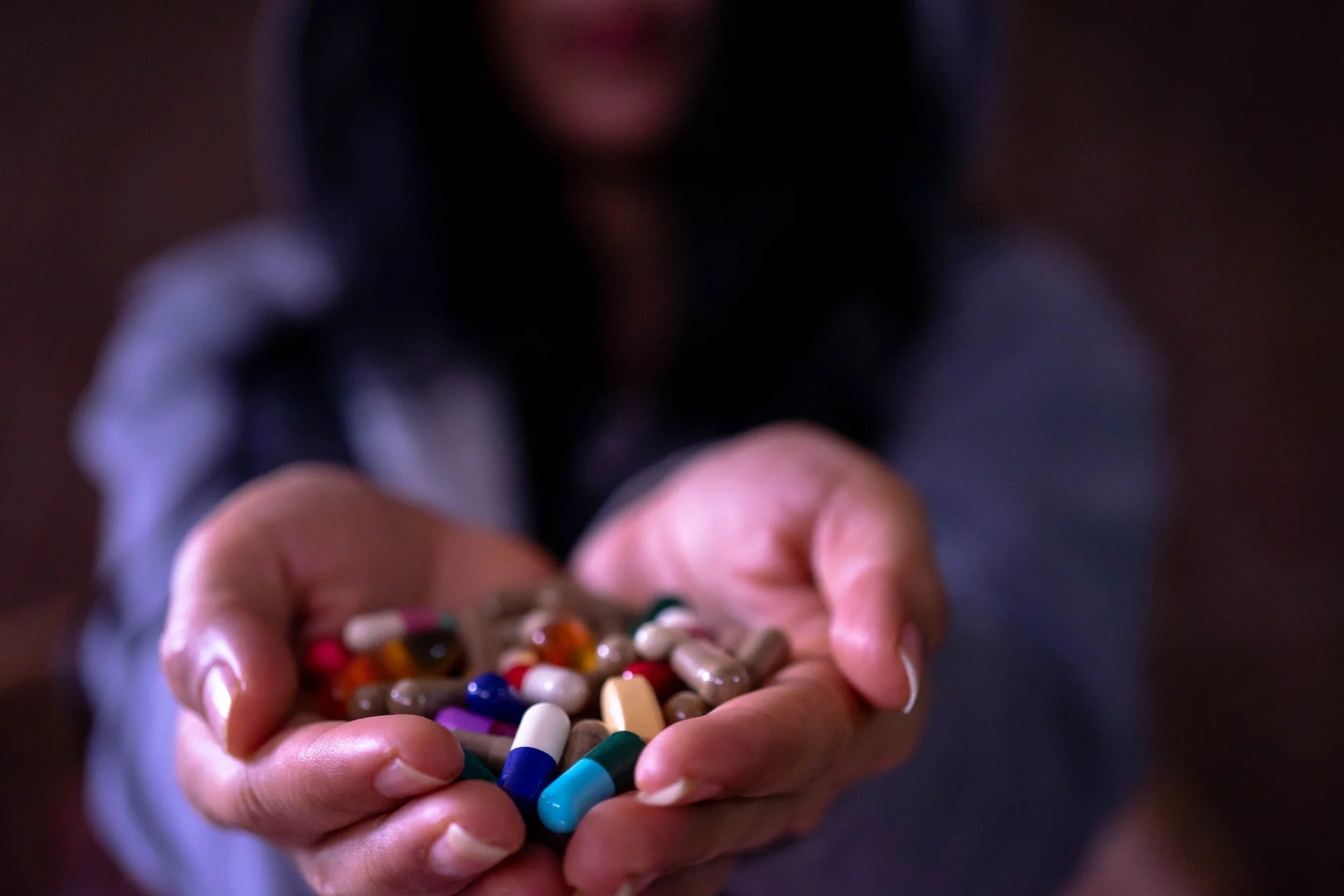 Person holding a variety of colorful antidepressant pills, symbolizing the complexities of antidepressant misuse and dependence.