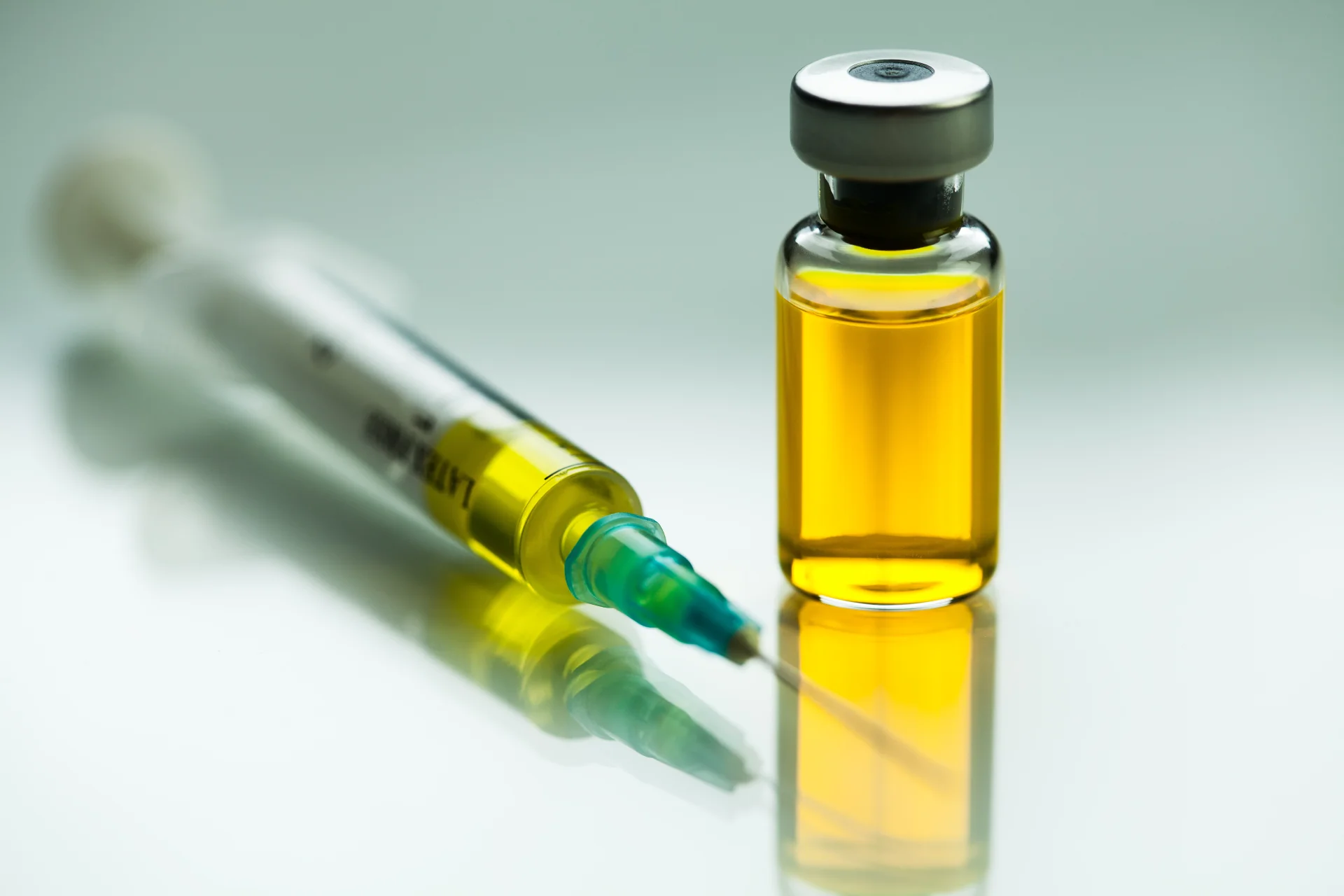 Syringe with green needle and vial containing yellow liquid, representing morphine for medical use in addiction treatment and detoxification.