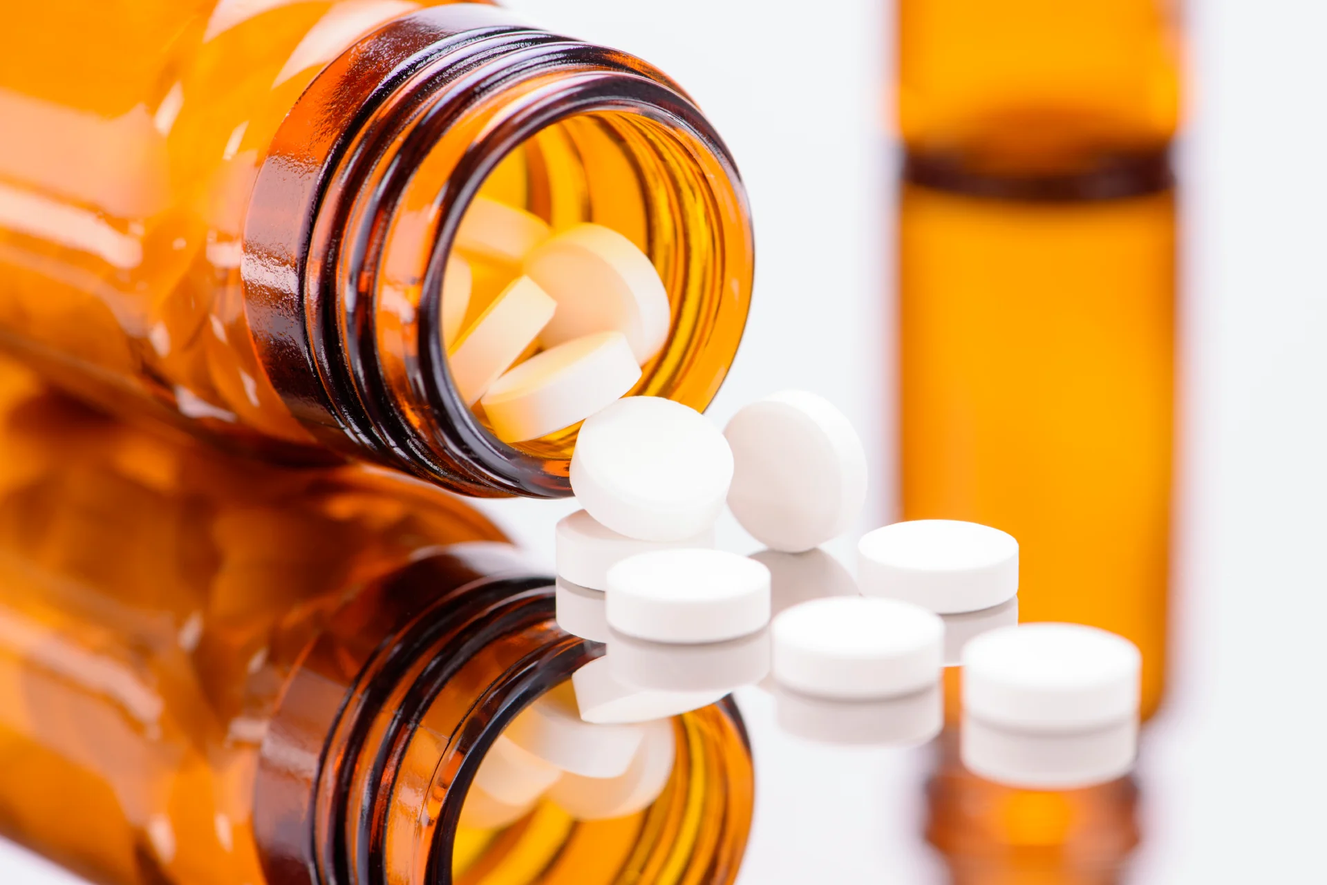 Amber prescription bottle with white pills spilled, representing benzodiazepines used for anxiety and insomnia treatment.