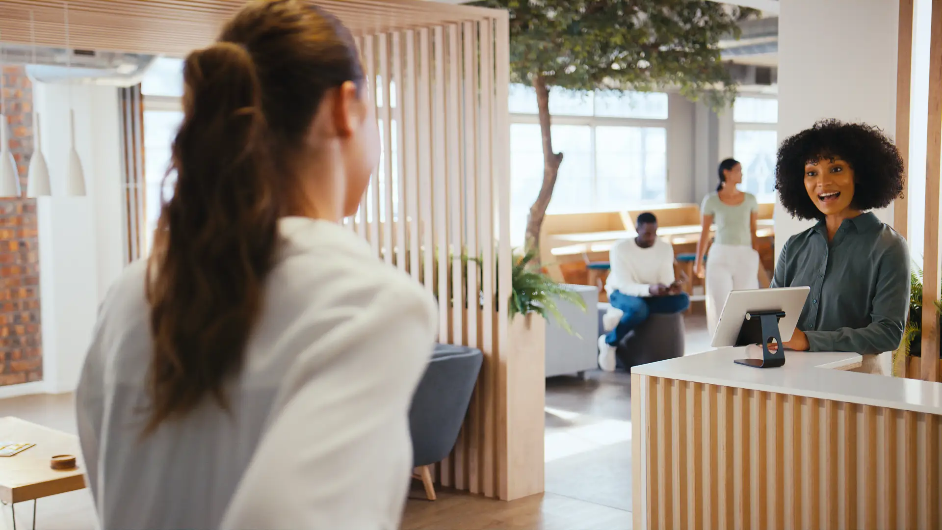 Businesswoman checking in at a reception desk in a modern, welcoming environment, emphasizing support for individuals seeking treatment for substance use and mental health challenges.