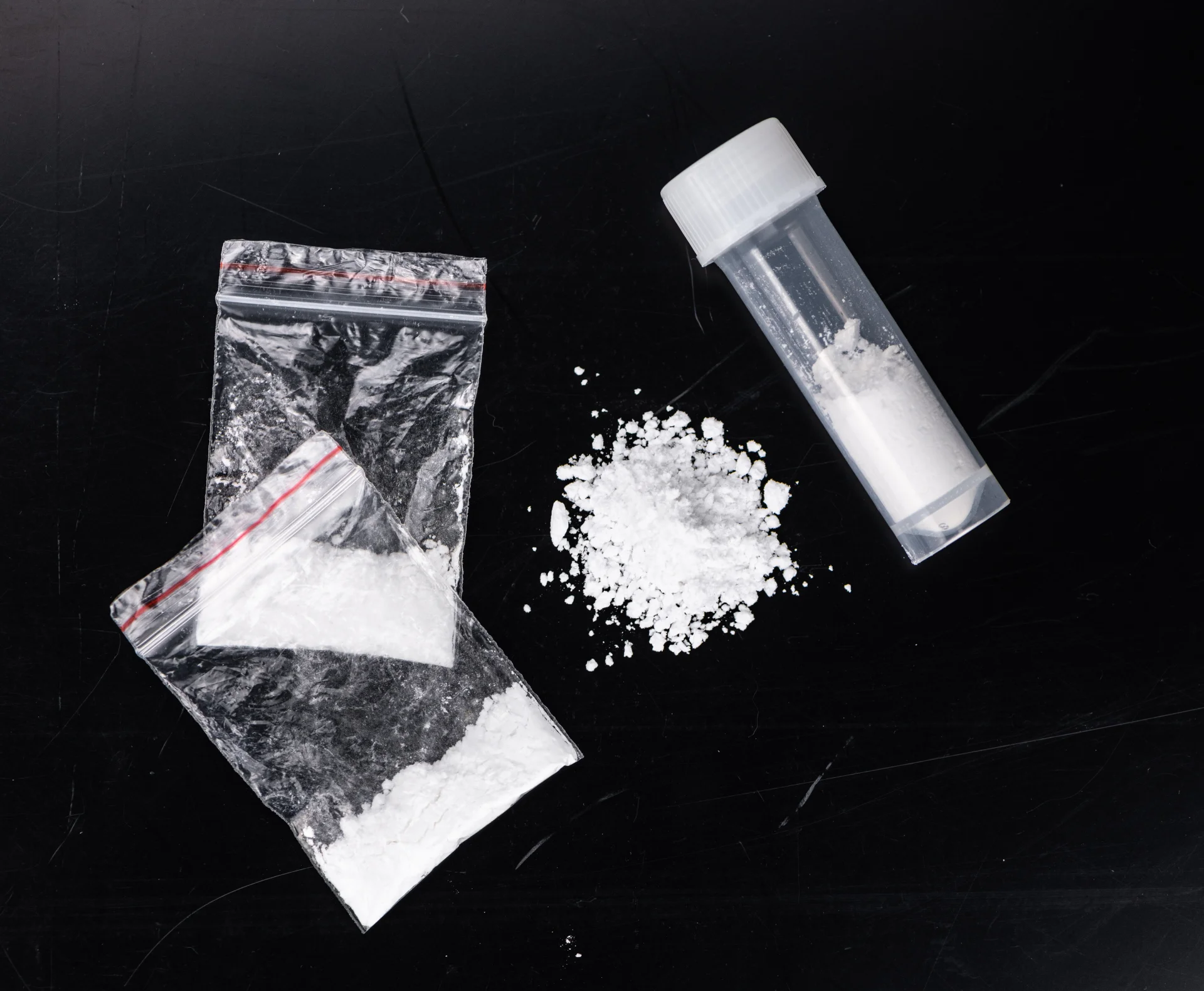 Bags and vial containing white powder resembling cocaine, highlighting substance use issues related to cocaine addiction and treatment resources on Long Island.