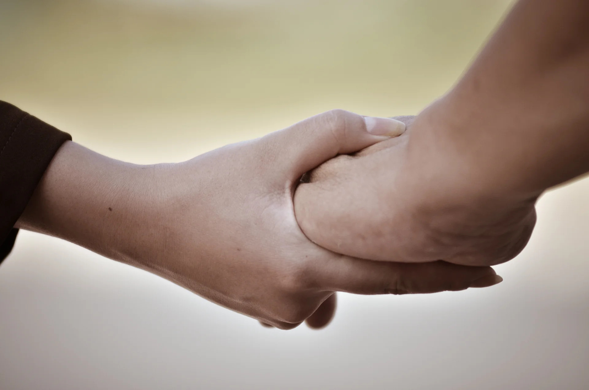 Hands clasped together symbolizing support and connection in addiction recovery.