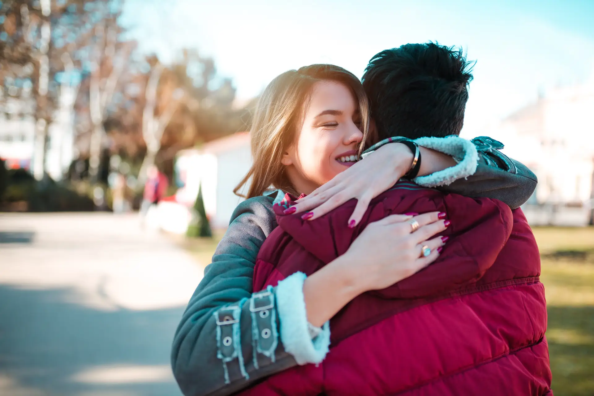 Young couple embracing outdoors, symbolizing support and connection in the context of aftercare for addiction recovery.