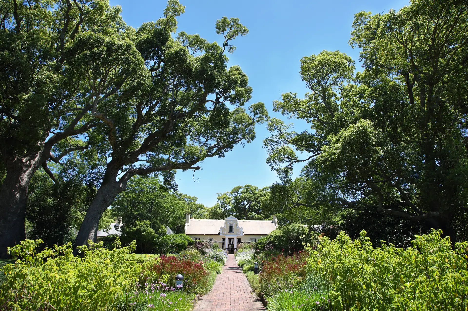 Residential treatment facility surrounded by lush greenery and colorful gardens, emphasizing a serene environment for recovery and rehabilitation.