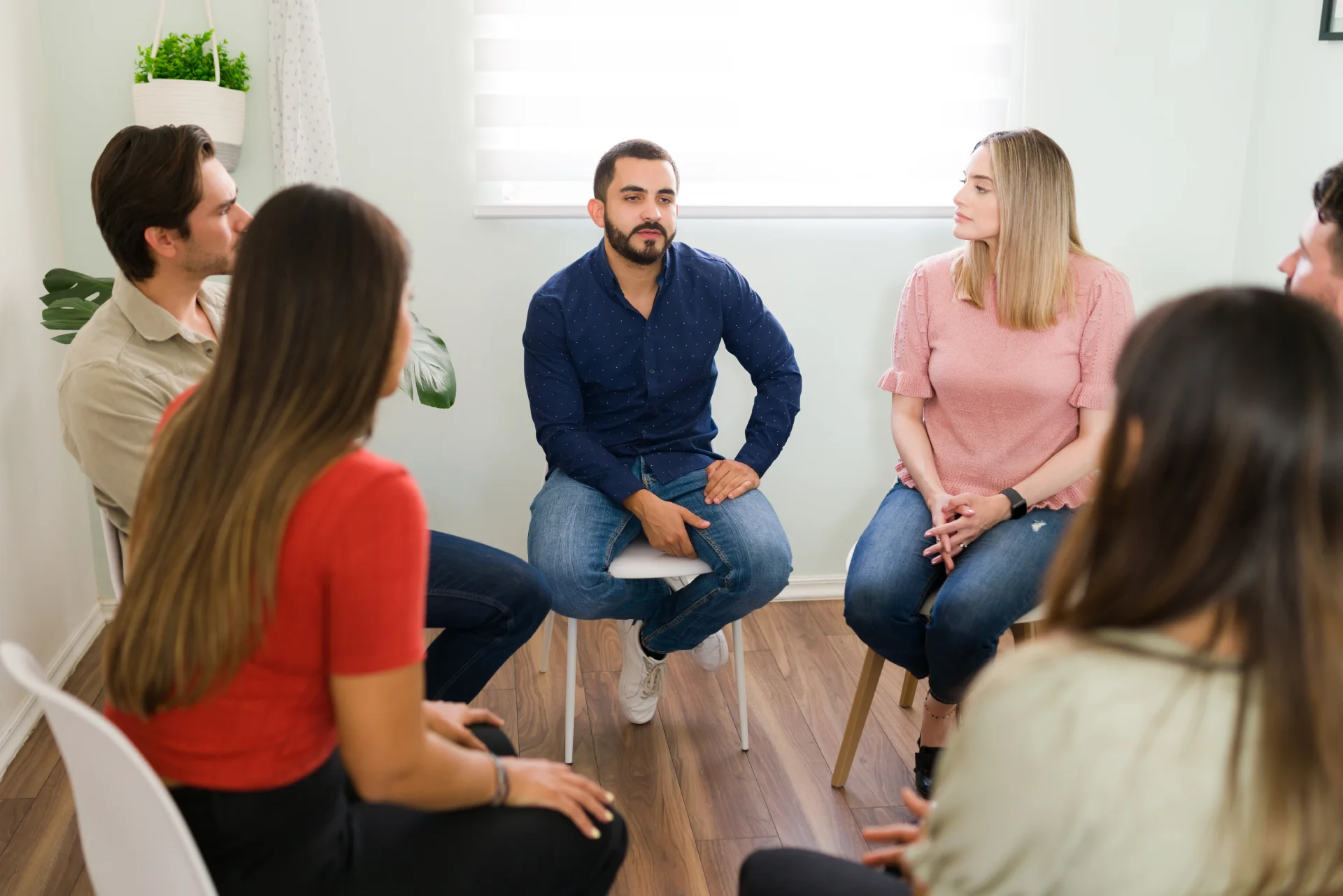 Support group meeting for addiction recovery, featuring diverse individuals engaged in discussion, emphasizing community and shared experiences in overcoming substance use challenges.
